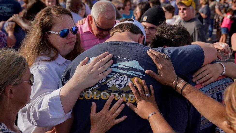 People embrace at a vigil