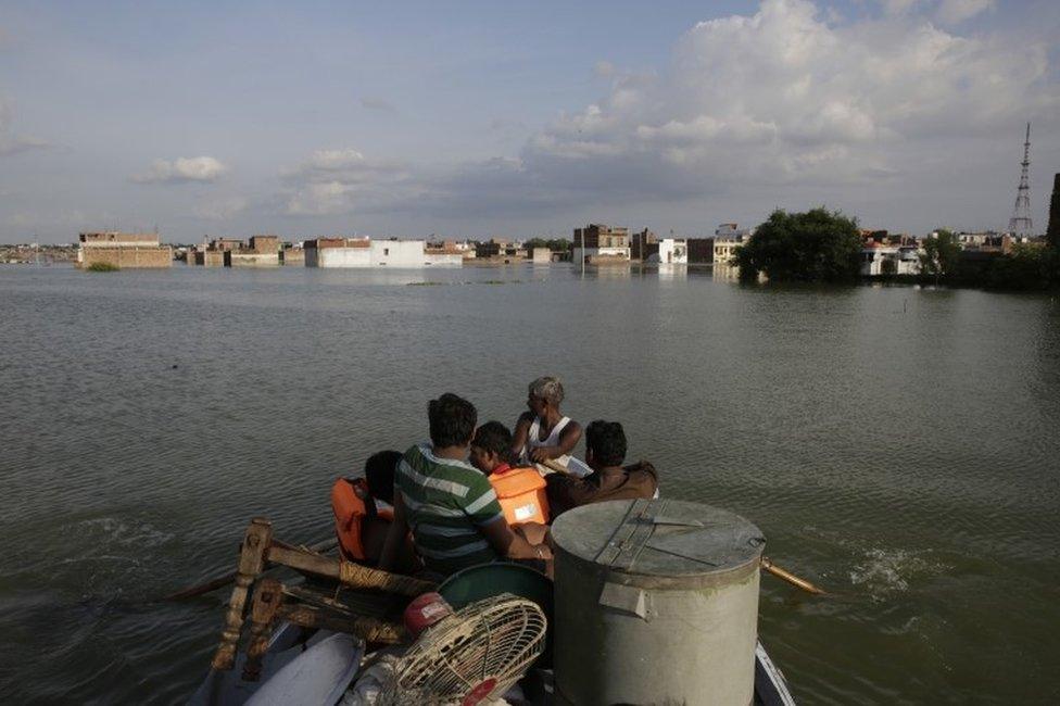 Rescuers shift residents to safer places following floods in the River Ganges in Allahabad, India, Sunday, Aug. 21, 2016.