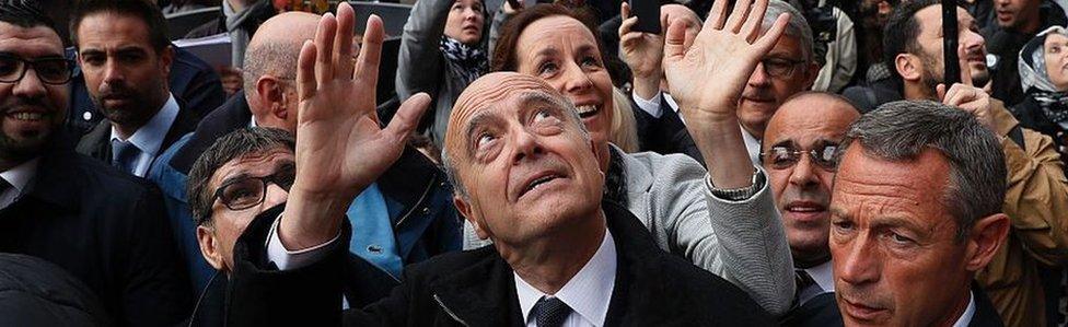 Bordeaux's mayor and right-wing Les Republicains (LR) party's candidate for the party's primary ahead of the 2017 presidential election, Alain Juppe (C) waves as he visits the Dalle d'Argenteuil, in the north-western suburbs of Paris, on 2 November 2016