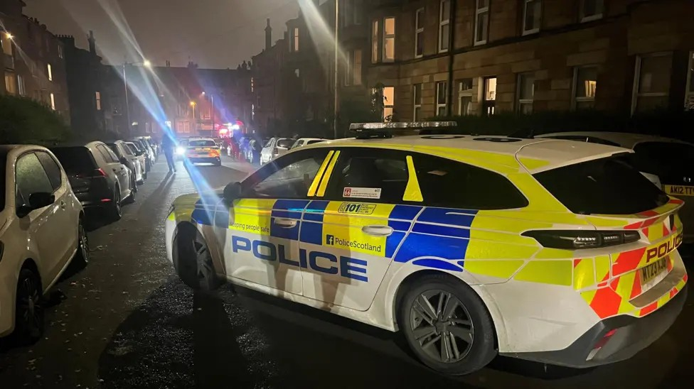 Police cars on Herriot Street where a car was set on fire