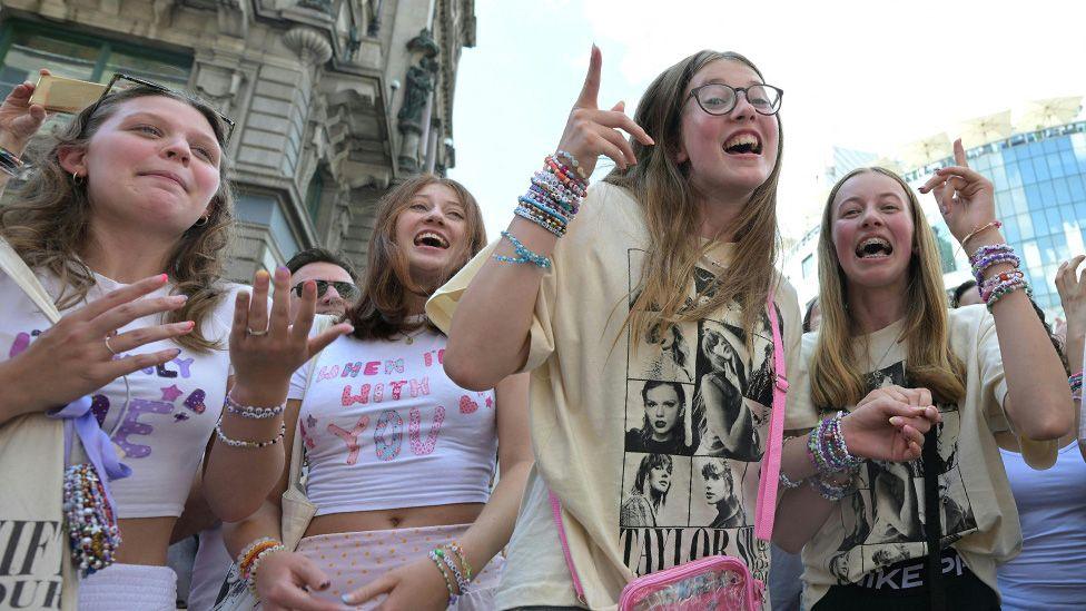 A group of young Taylor Swift fans singing on the streets of Vienna