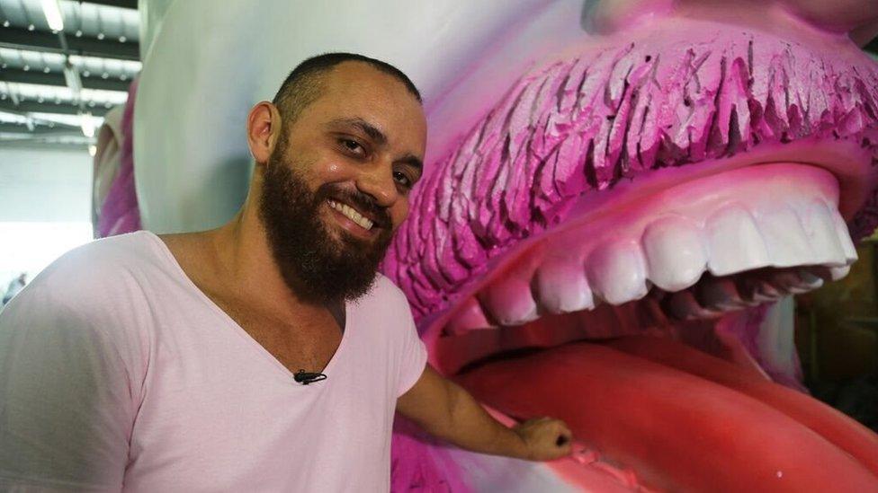 Leandro Vieira poses next to one of the floats