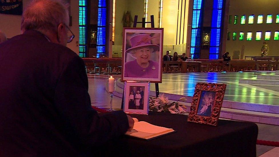 Man signing book of condolence in cathedral