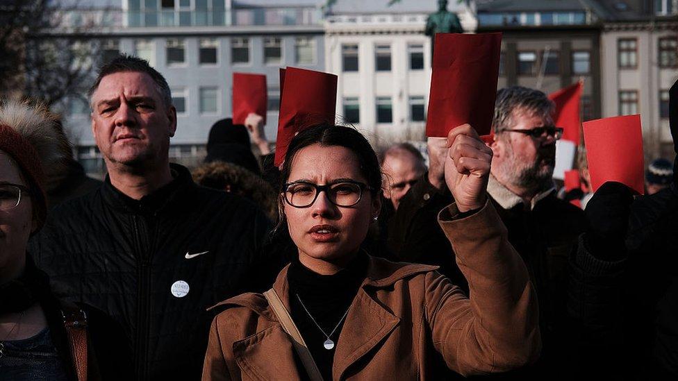 Hundreds of protesters gather in front of the parliament building holding red cards for a fourth day on 7 April 2016 in Reykjavik, Iceland after Prime Minister Sigmundur David Gunnlaugsson stepped down on revelations in the Panama Papers that he hid his assets in an offshore shell-company