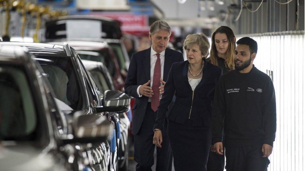 Theresa May and Chancellor Philip Hammond at a Jaguar Land Rover factory in Solihull