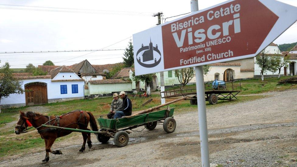 Men ride a carriage in Viscri in 2010