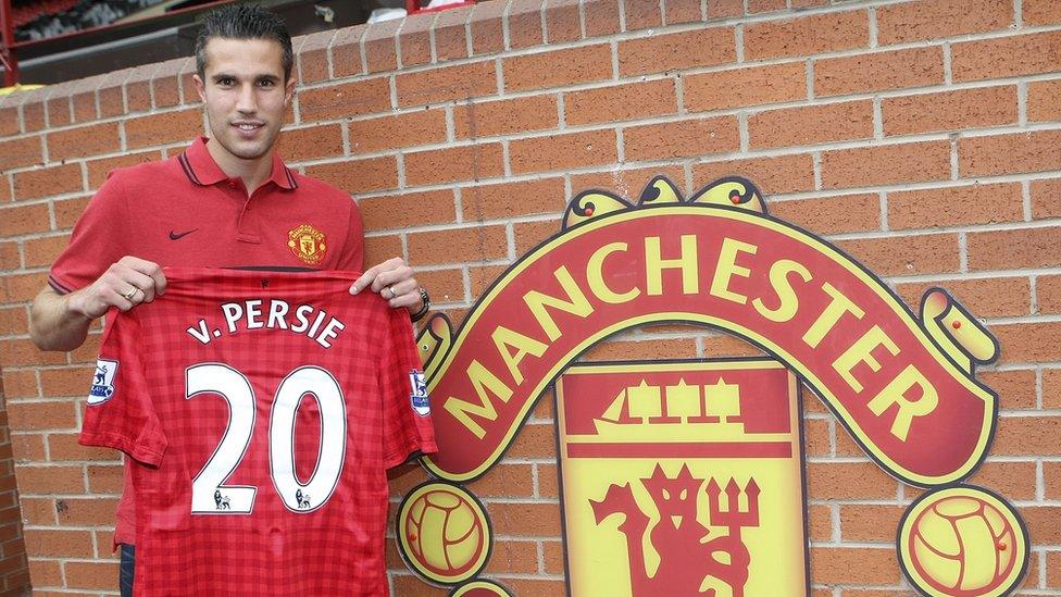 Robin Van Persie holding his Manchester United shirt.