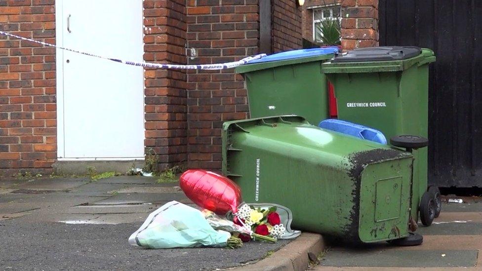 Knocked over bin and floral tributes at the police cordon on Titmuss Avenue