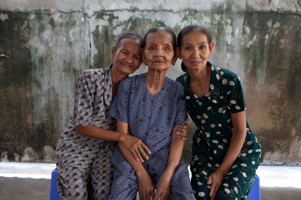 Do Thi Net sits with her daughters Nguyen Thi Ten and Nguyen Thi Sen