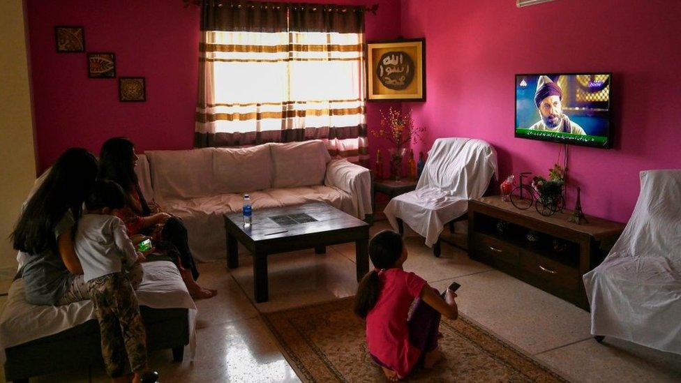 In this picture taken on May 9, 2020, a family watches a Turkish drama series "Dirilis: Ertugrul" telecasted on Pakistan's state-run channel PTV Home during the holy month of Ramadan in Islamabad