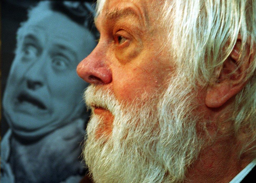 Baldessari with old photo in his studio