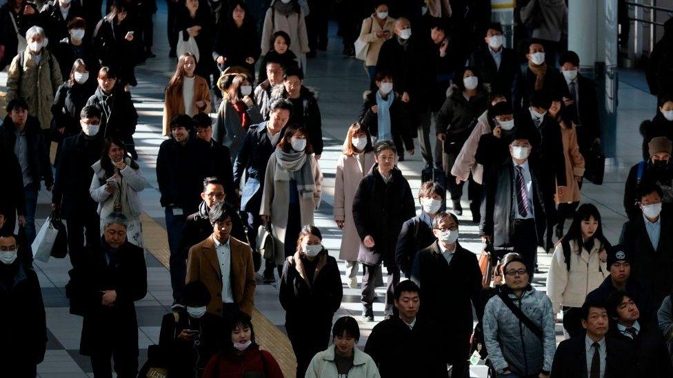 Commuters walk on concourse at a railway's terminal station in Tokyo on January 31, 2020.