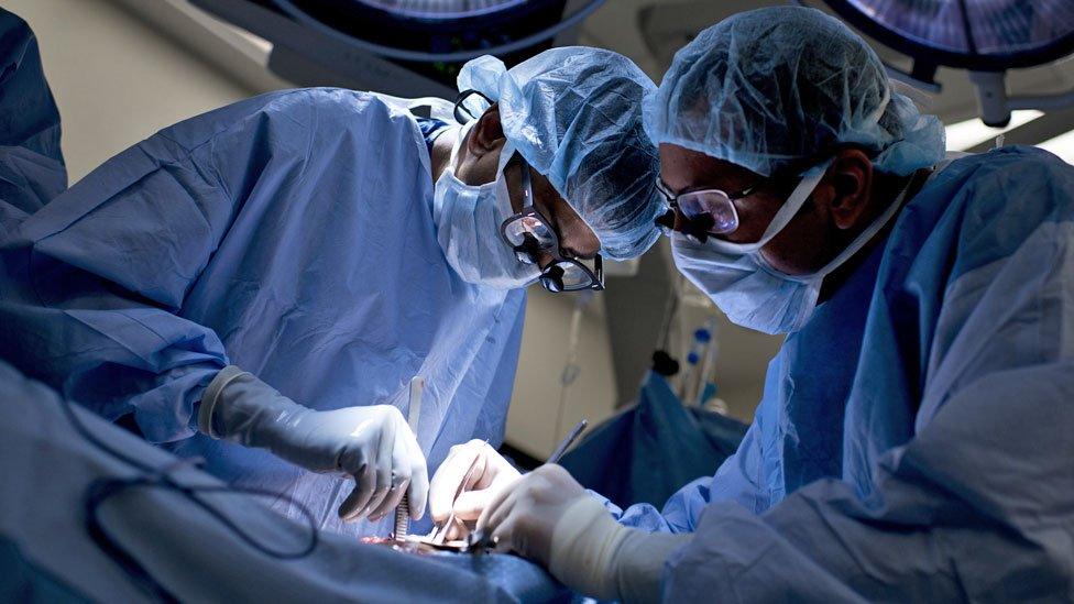 Surgeons at work on a patient in an operating theatre