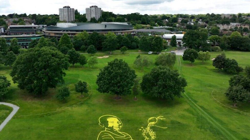 Giant tennis ball mosaic near No.1 Court showing Tefy from Madagascar enjoying clean water.