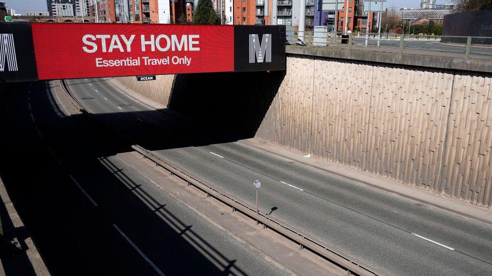 sign-reads-stay-home-essential-travel-only-above-manchester-motorway