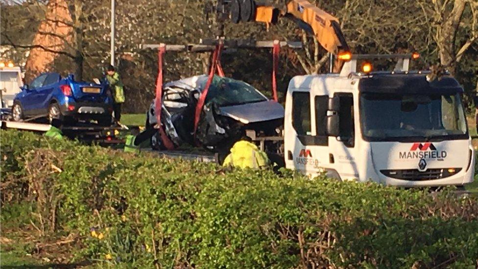 Two cars are lifted onto lorries