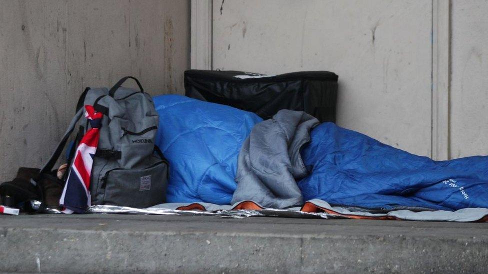 A homeless person sleeping rough in a doorway