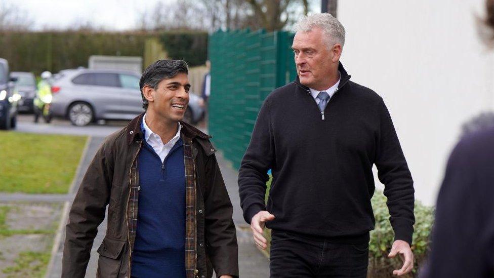 Prime Minister Rishi Sunak walking and speaking with Conservative Party deputy chairman Lee Anderson