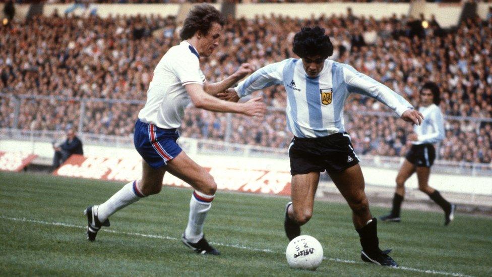 England's Phil Neal challenges Argentina's Diego Maradona for possession of the ball