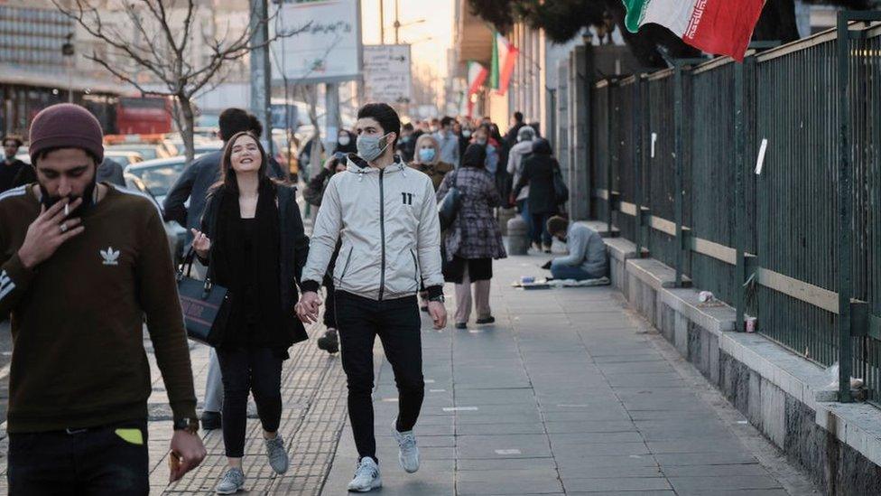 People walk down a street in Tehran, Iran (1 February 2021)