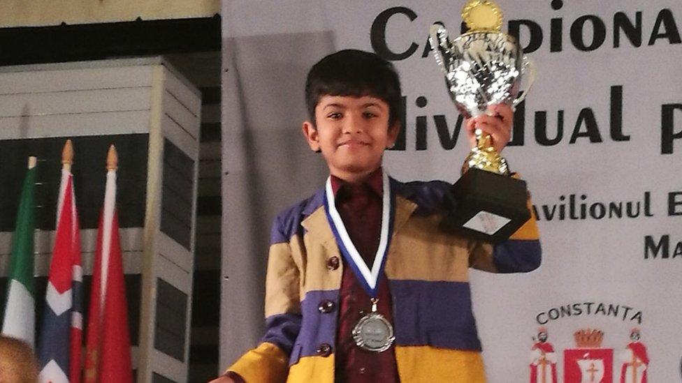 Shreyas Royal holding a trophy.