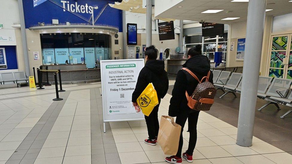 People looking at a board informing passengers of industrial action