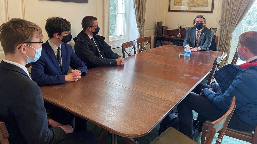 Students and minister sat around a table