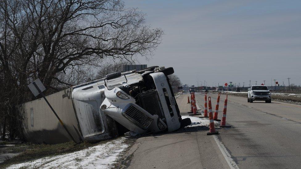 A large trailer truck is seen flipped sideways on highway 59 in Texas