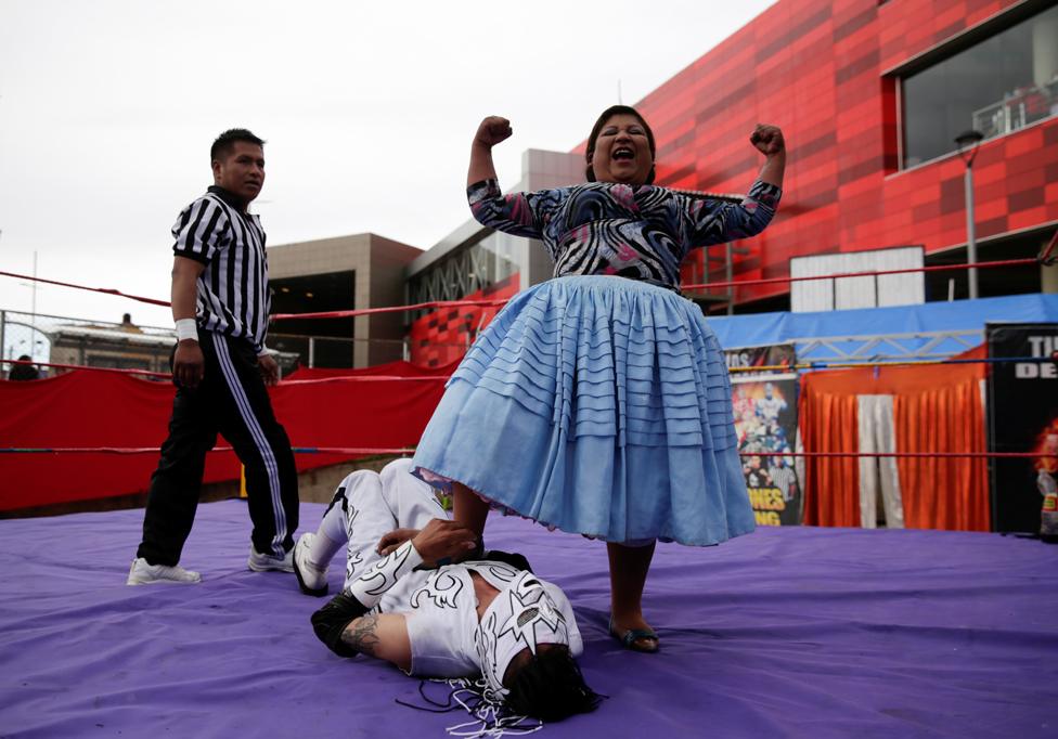 A cholita wrestler celebrates her win