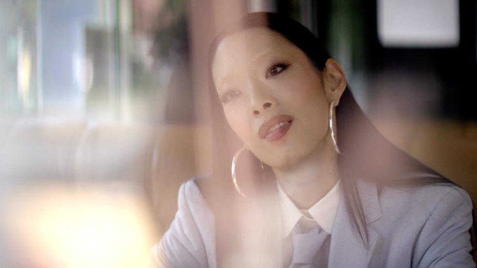 Rina Sawayama sitting in a cafe