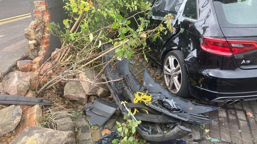 A damaged car and wall in Luton