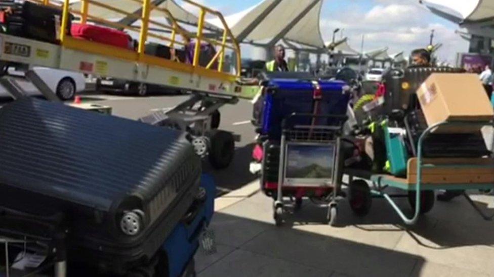 baggage handlers load luggage onto a plane