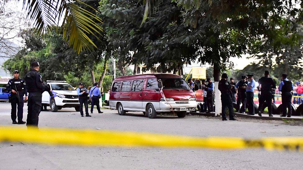 Members of the Honduran Police stand guard next to a vehicle allegedly used in a shooting