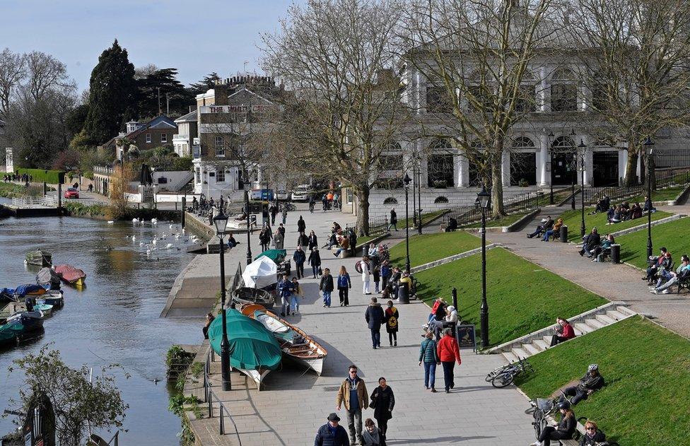 People are seen relaxing along the waterfront beside the River Thames, as the number of coronavirus disease cases (COVID-19) grow around the world, Richmond, south west London