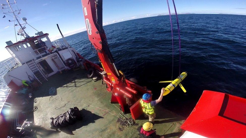 A undated Navy file photo shows crew members aboard the VOS Raasay recover US and British Royal Navy ocean gliders taking part in the Unmanned Warrior exercise off the northwest coast of Scotland in October 2016.