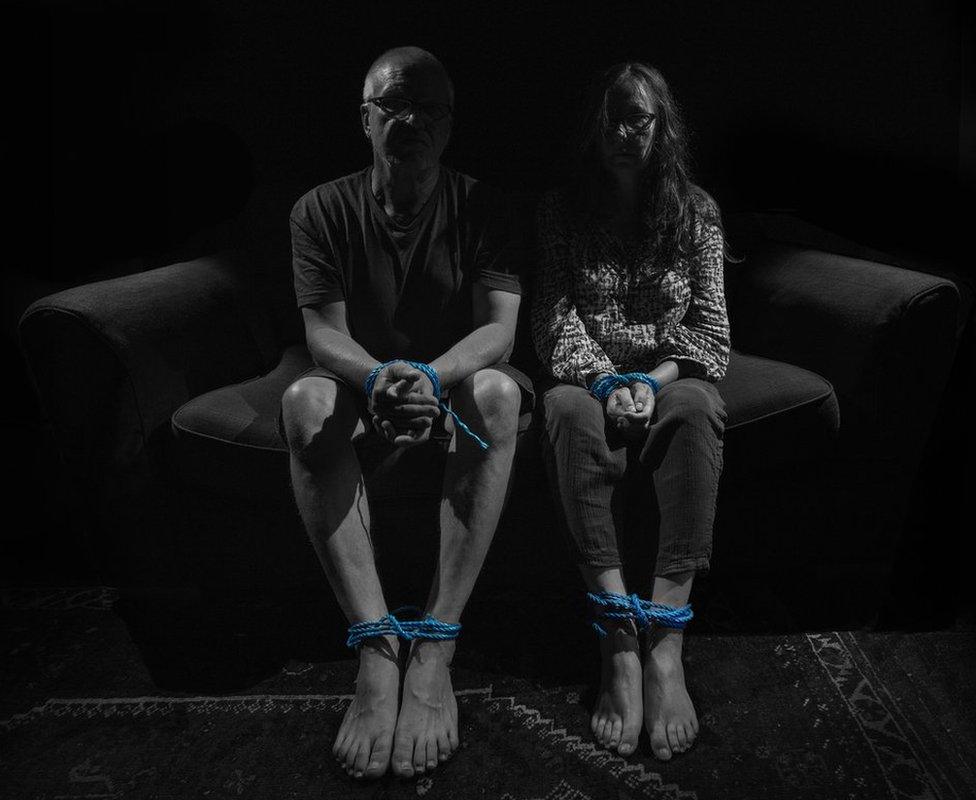 A man and a woman with their hands and feet bound with rope as a sign of the torment during the pandemic.