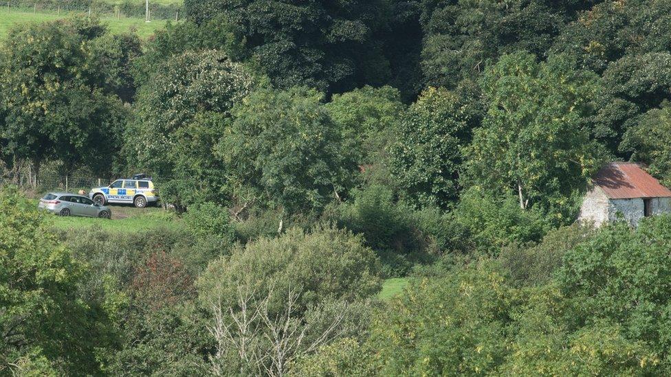 Police vehicles at the search site near Killen