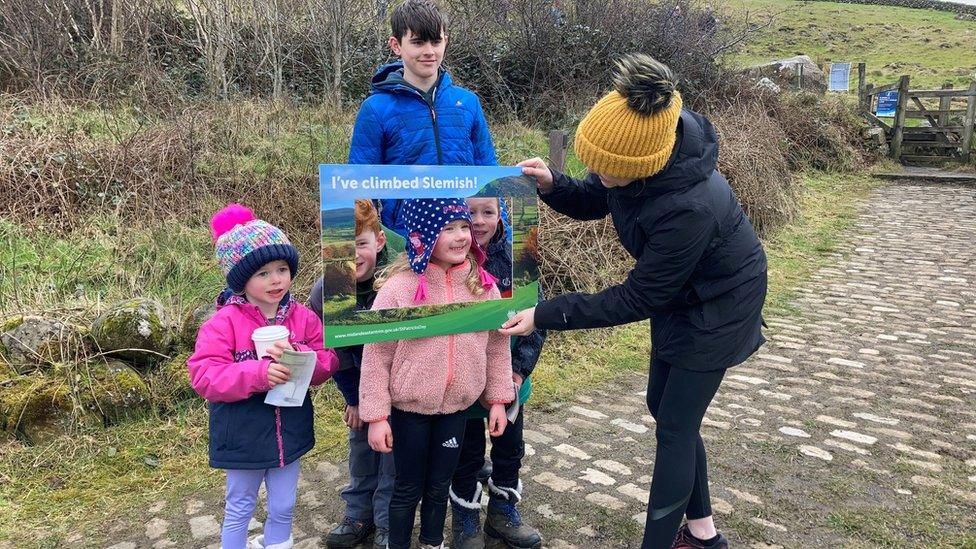 Families pose for pictures after climbing Slemish