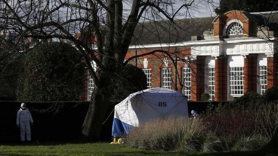 Forensic police officers stand by a forensic tent near the grounds of Kensington Palace