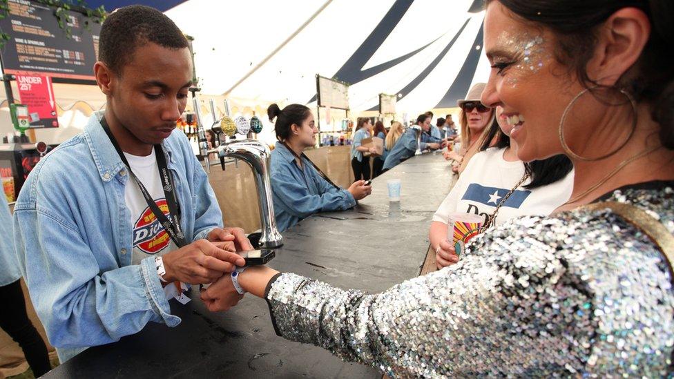 Festival attendee uses a wristband to pay