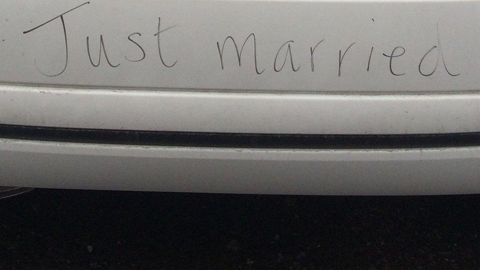 Just married written on rear bumper of car