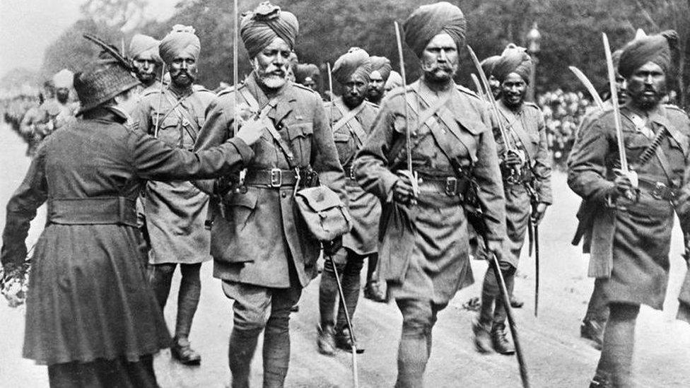 During a march past of Indian troops, a woman pins flowers on to the tunic of one of the soldiers.