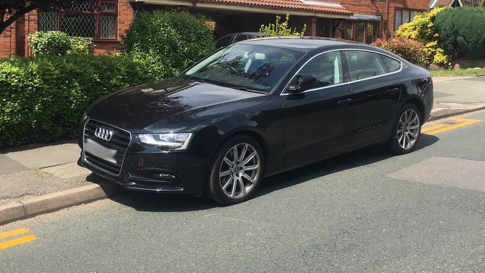 Car parked in gaps in double yellow lines