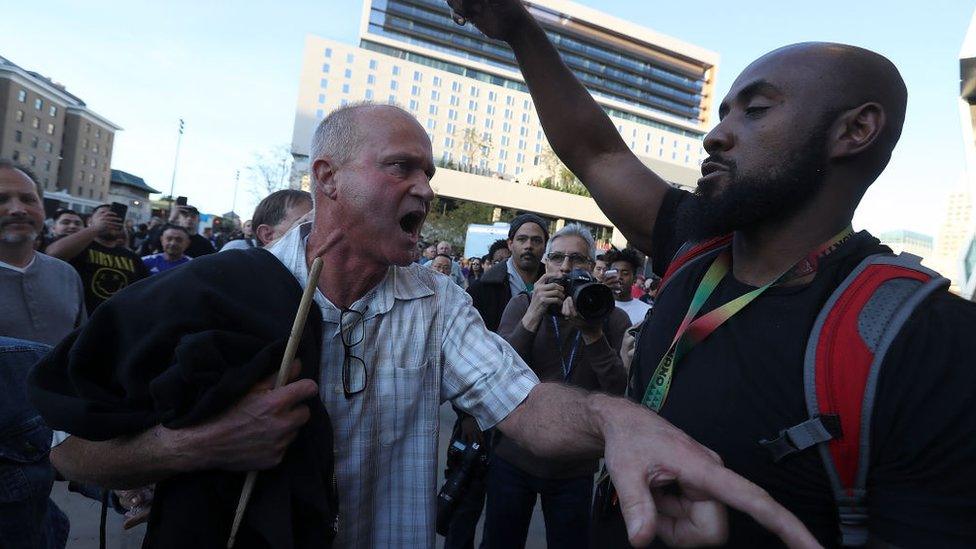 A fan trying to enter the arena argues with a Black Lives Matter demonstrator