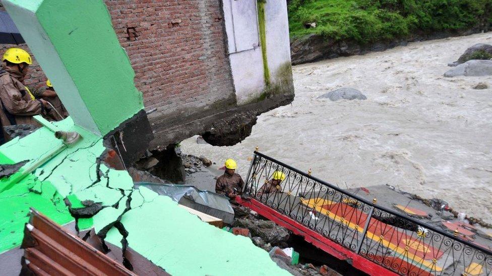 In this photograph taken on July 3, 2016, Indian State Disaster Response Force (SDRF)personnel examine the wreckage of a building after monsoon floodwaters devastated dwellings in the village of Ghat, near Karanprayag, Chamoli District in the northern state of Uttarakhand.