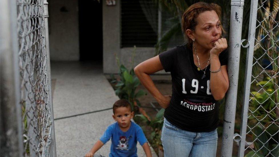 A woman cries at the entrance of her home during a blackout in Maracaibo