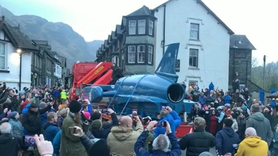 Crowds welcomed Bluebird as it arrived in Coniston on the back of a lorry