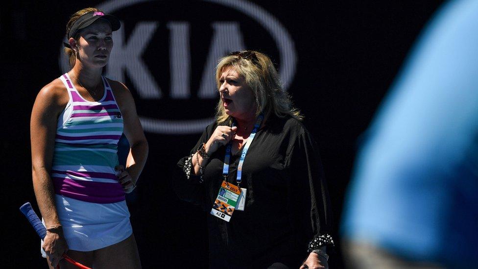 An official speaks with Danielle Collins of the US after the organisers decided to close the court's roof due to the hot weather during her women's singles semi-final match