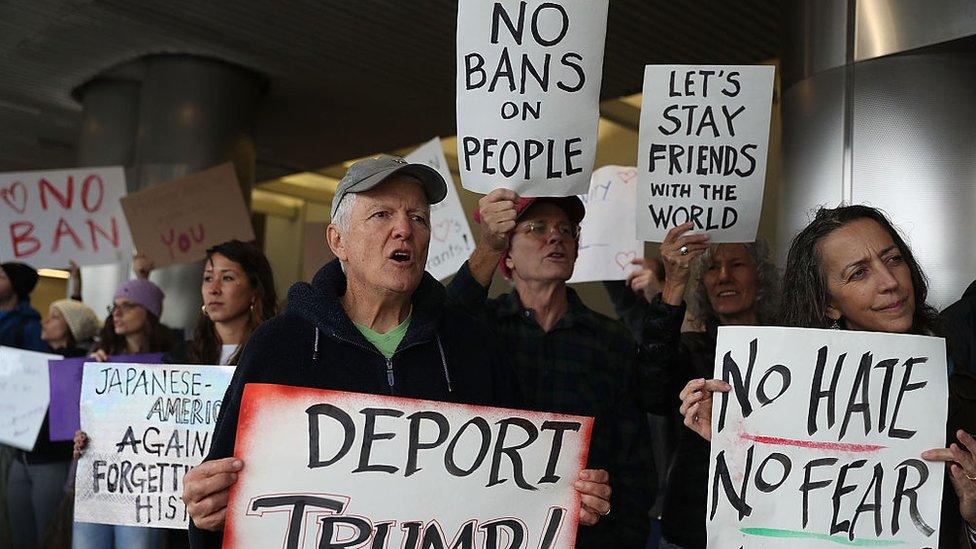 Protesters stand together at the Miami International Airpor