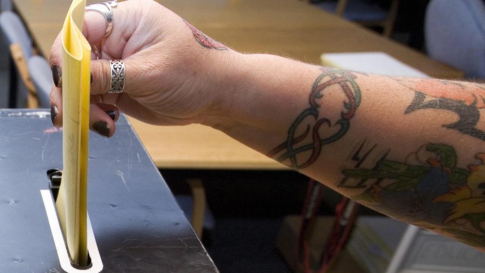 A voter places her voting paper in the ballot box at a polling station in Grays, Essex on June 4, 2009